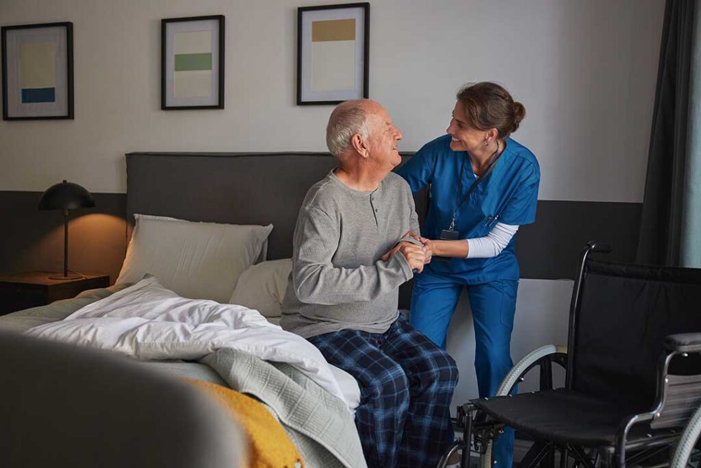Staff member reviews a medication list with an older resident at a dining table.